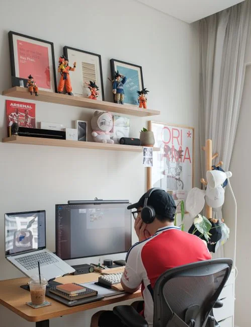 Gros plan sur des mains tapant sur un ordinateur portable, à côté d’une tasse de café posée sur un bureau en bois.